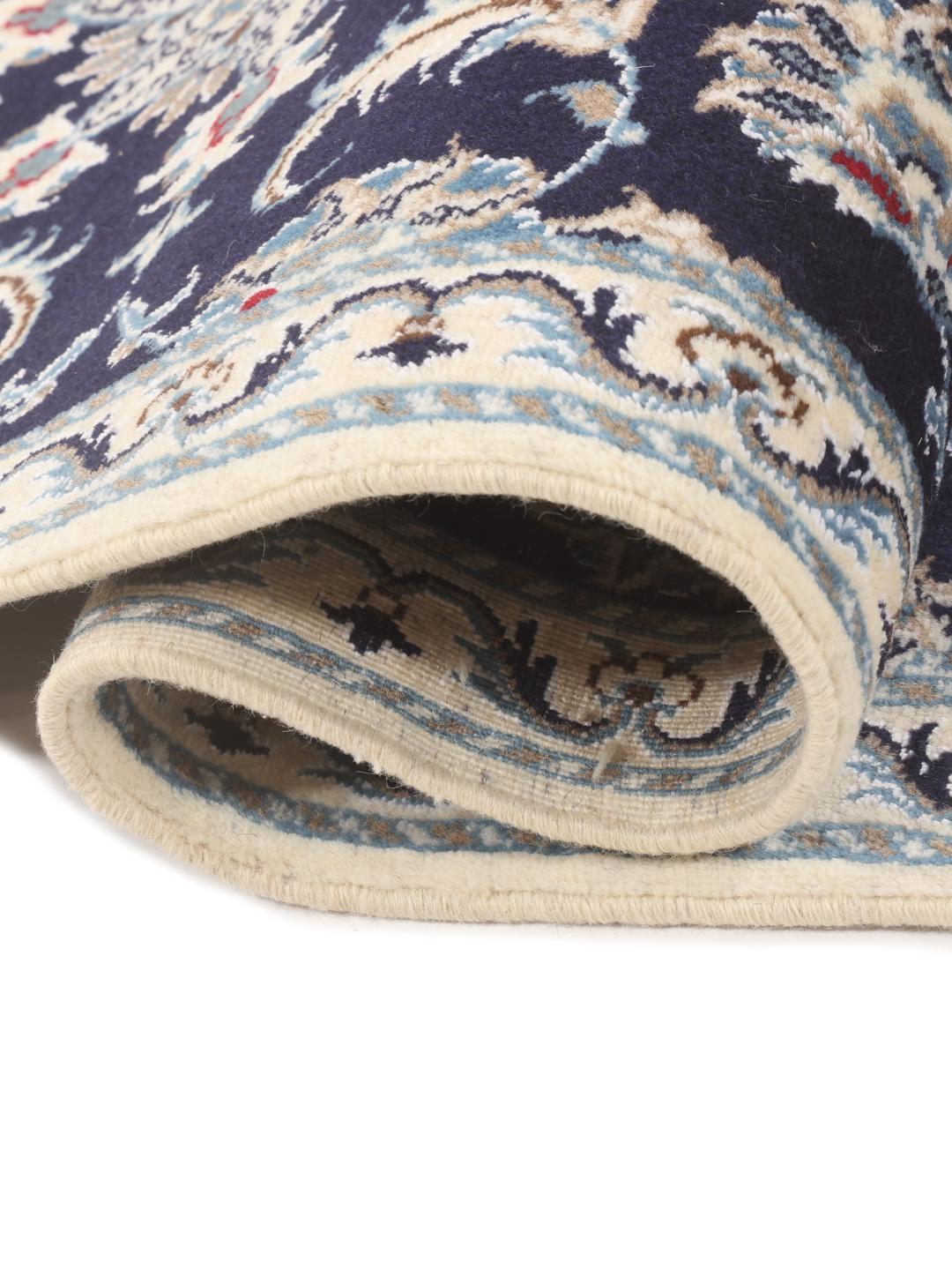 A hand-knotted Nain runner from the Middle East in dark blue with floral patterns.