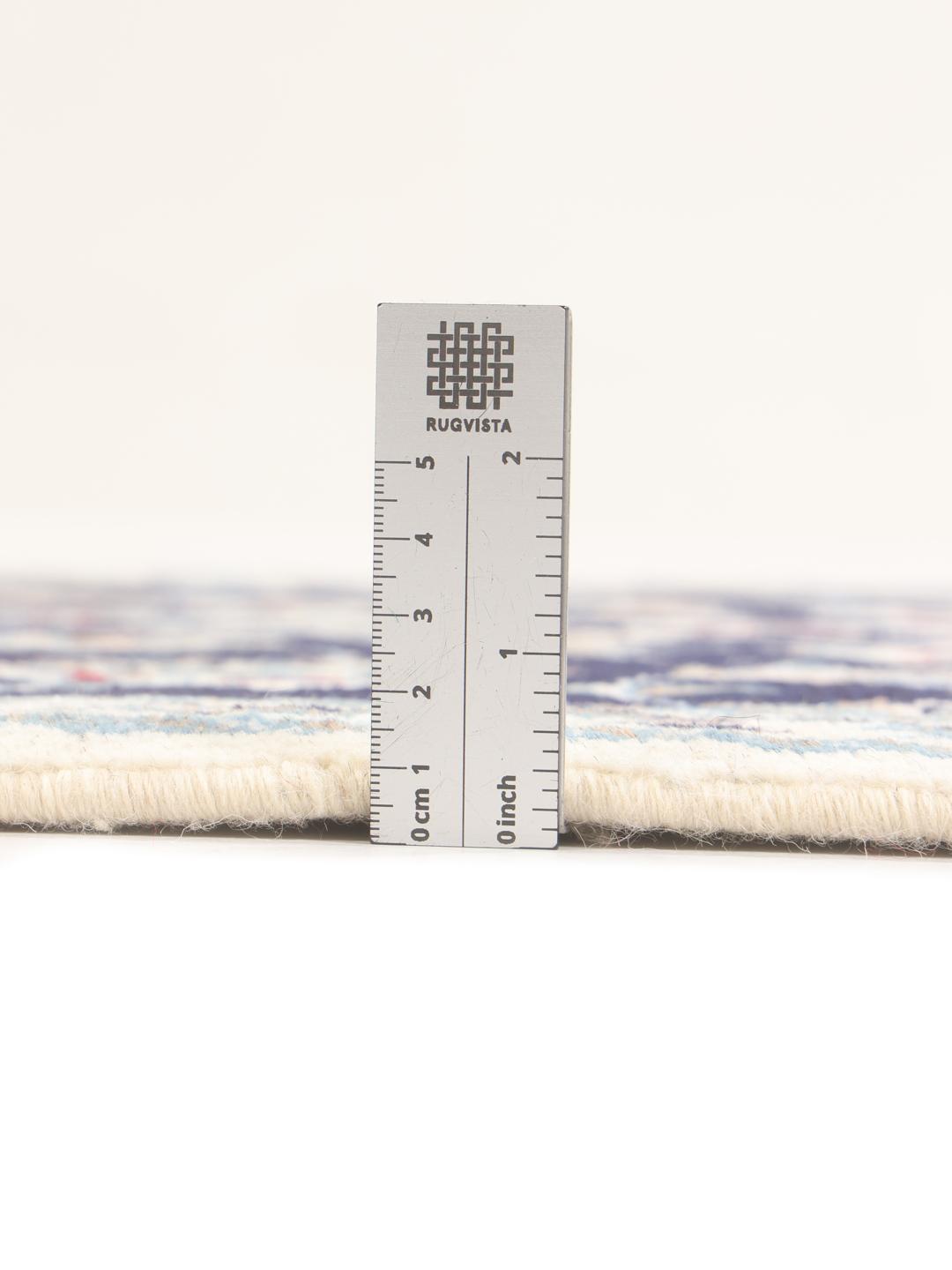 A hand-knotted Nain runner from the Middle East in dark blue with floral patterns.