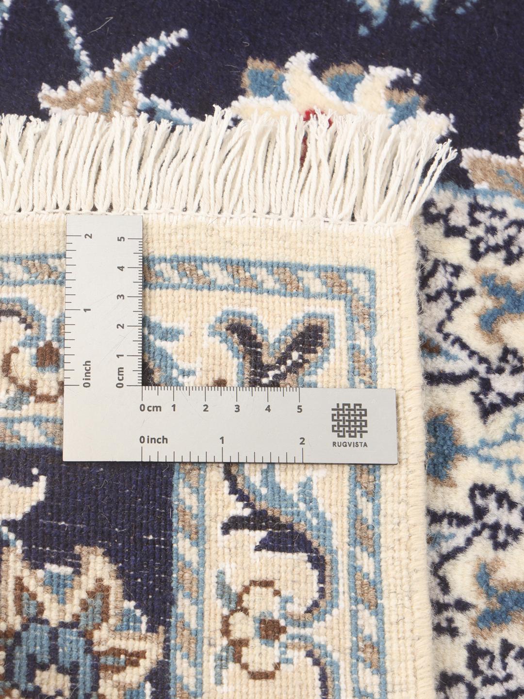 A hand-knotted Nain runner from the Middle East in dark blue with floral patterns.