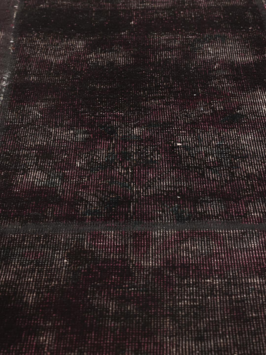 Een vierkant zwart patchwork vloerkleed afkomstig uit het Midden-Oosten.