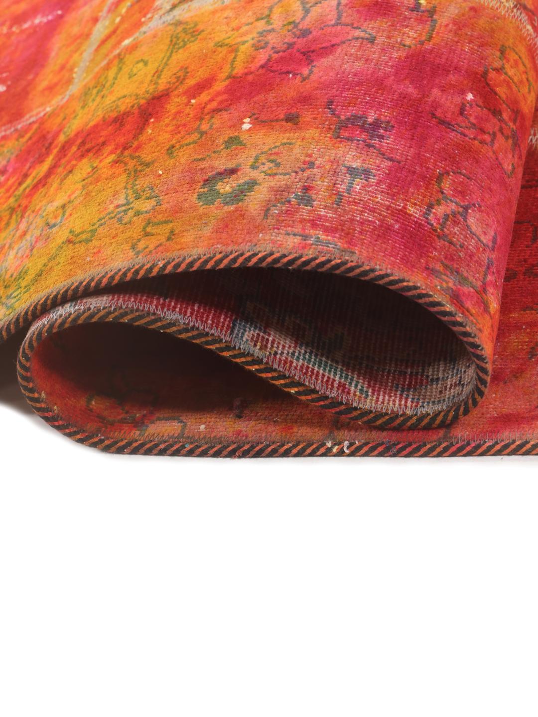 Un tapis patchwork rectangulaire vibrant provenant du Moyen-Orient, présentant un mélange de motifs floraux rouges et orange.