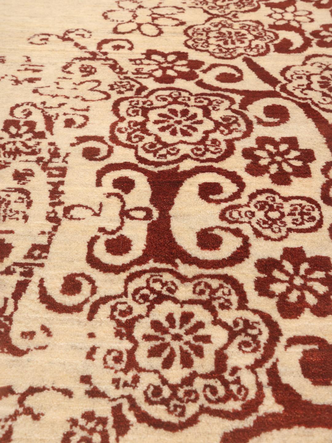 Et håndknyttet Gabbeh Fine-tæppe fra Mellemøsten med et blomstermønster i rød på en beige baggrund.
