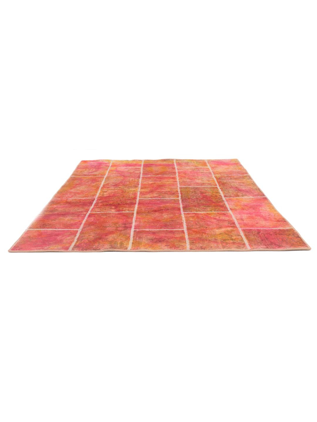 A vibrant red and orange patchwork rug with intricate patterns and a textured Wool pile.