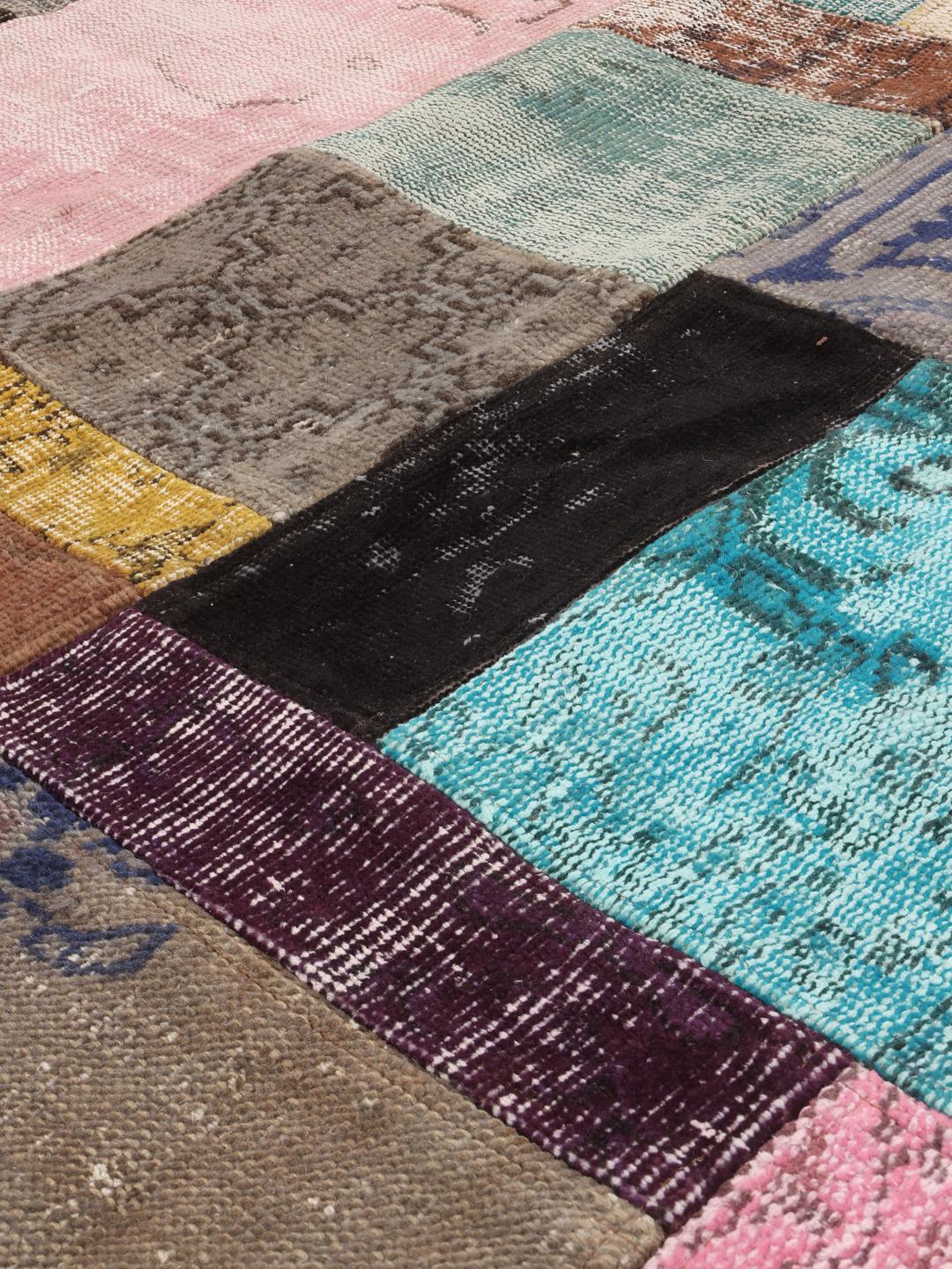 Een levendig handgemaakt Turks patchwork vloerkleed met een veelkleurig ontwerp.