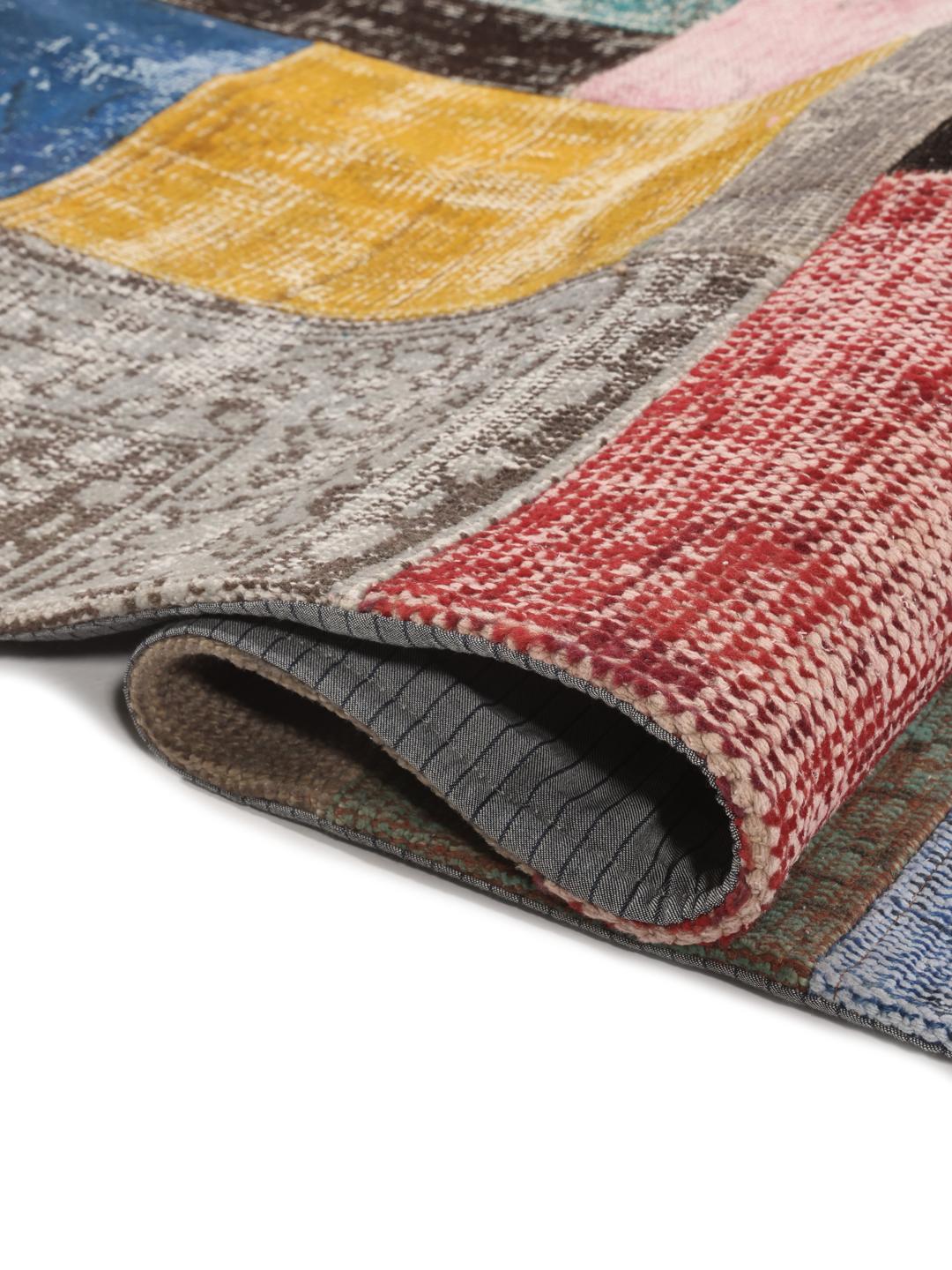 Een levendig handgemaakt Turks patchwork vloerkleed met een veelkleurig ontwerp.
