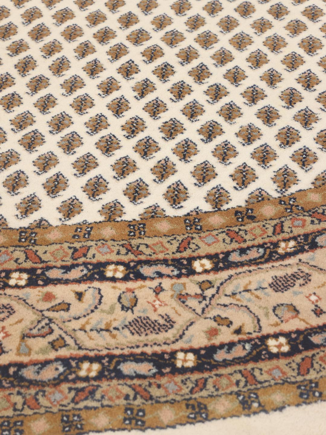 Een rond, handgeknoopt Mir Indo tapijt uit India met een beige veld en een gedetailleerde rand.