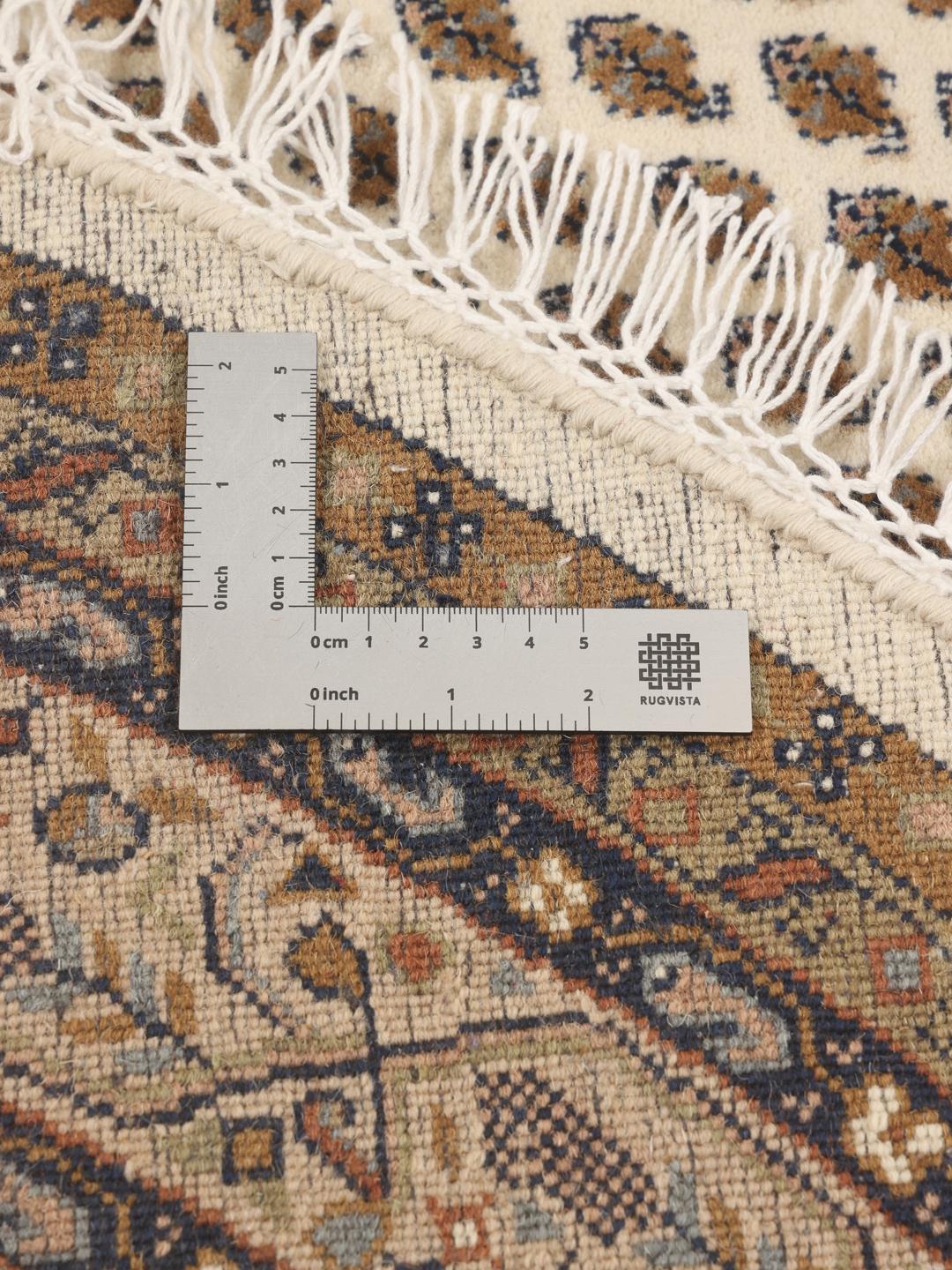 Un tapis rond en laine noué à la main Mir Indo beige avec un motif floral détaillé