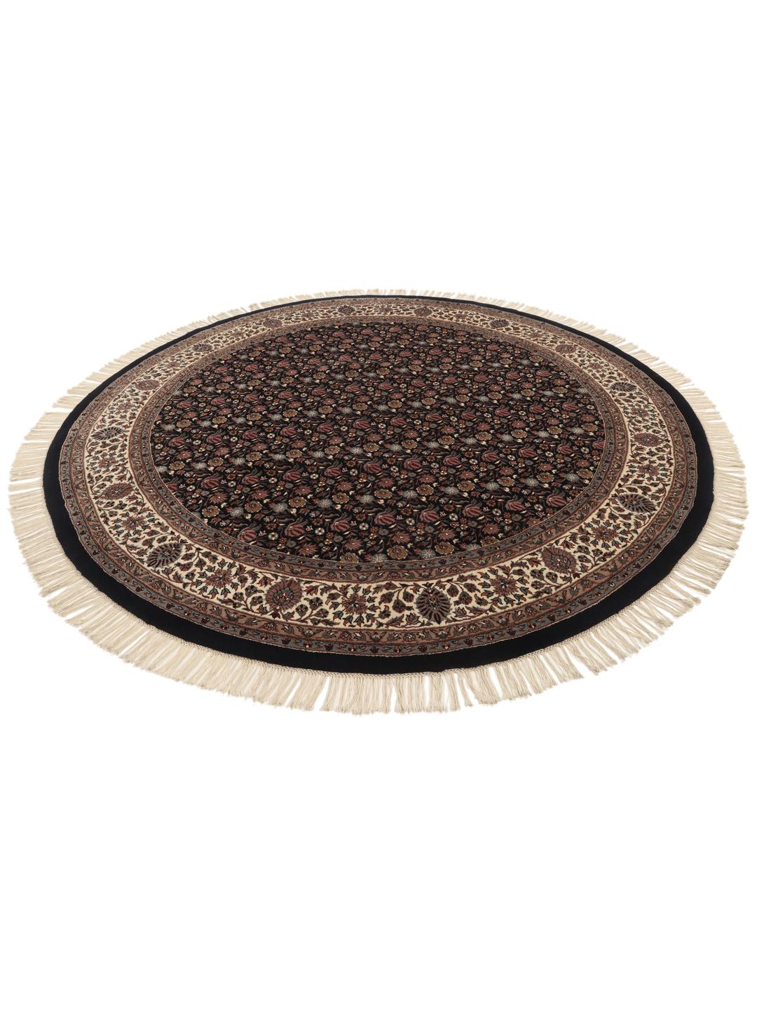 Rond handgeknoopt tapijt uit India met bloemmotieven in zwart en beige.