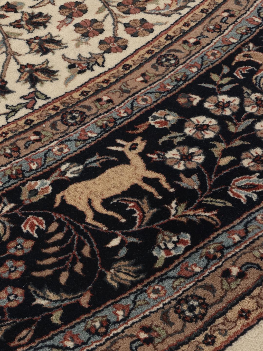Un tapis rond Sarough American beige et bleu foncé avec des motifs floraux et un médaillon central, originaire d'Inde.