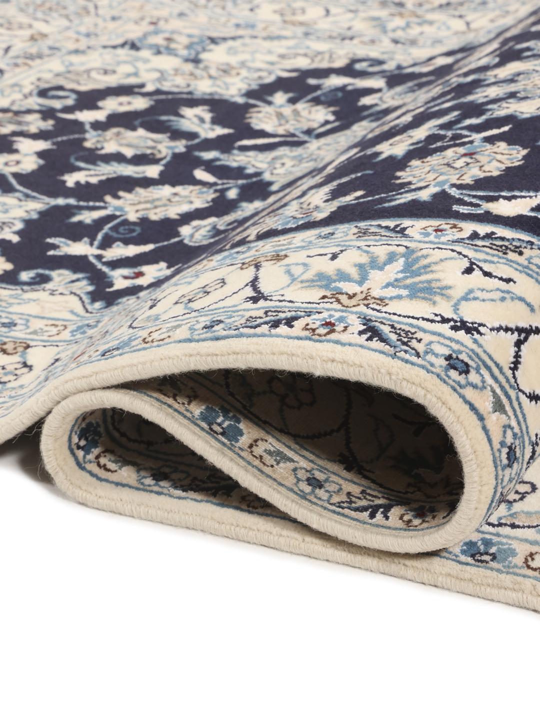 A hand-knotted Nain rug from the Middle East in dark-blue and cream tones.