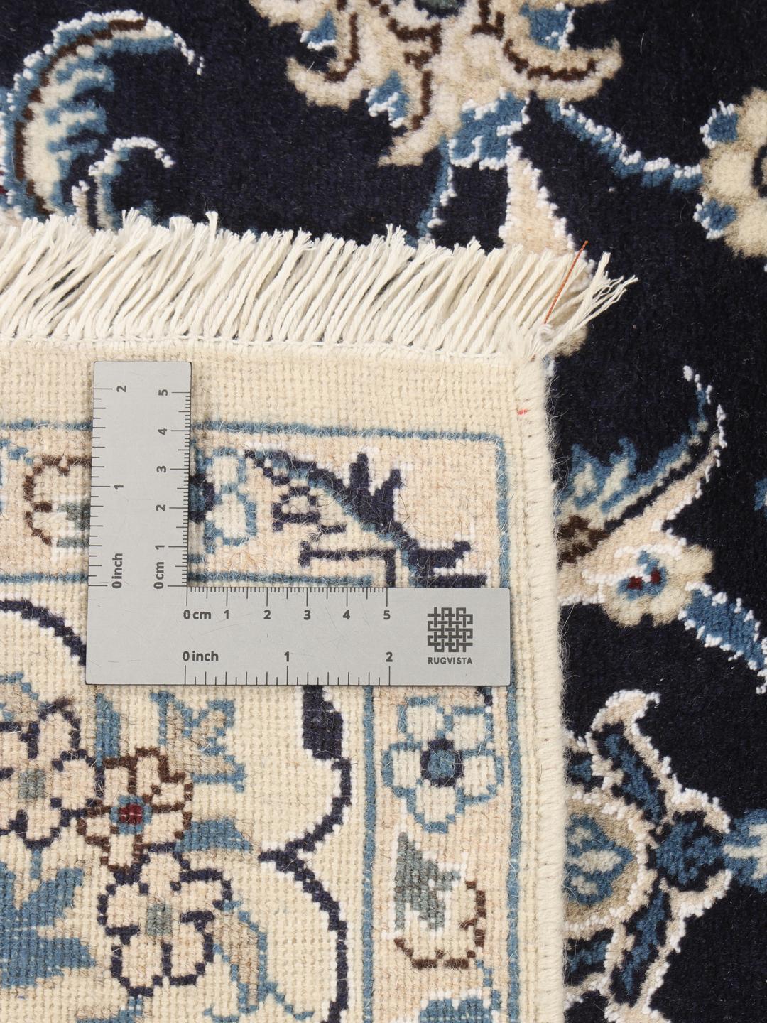 A hand-knotted Nain rug from the Middle East in dark-blue and cream tones.