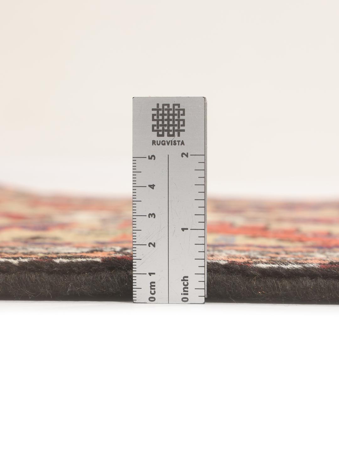 Een handgeknoopte Ardebil-loper uit het Midden-Oosten met een veelkleurig geometrisch ontwerp.