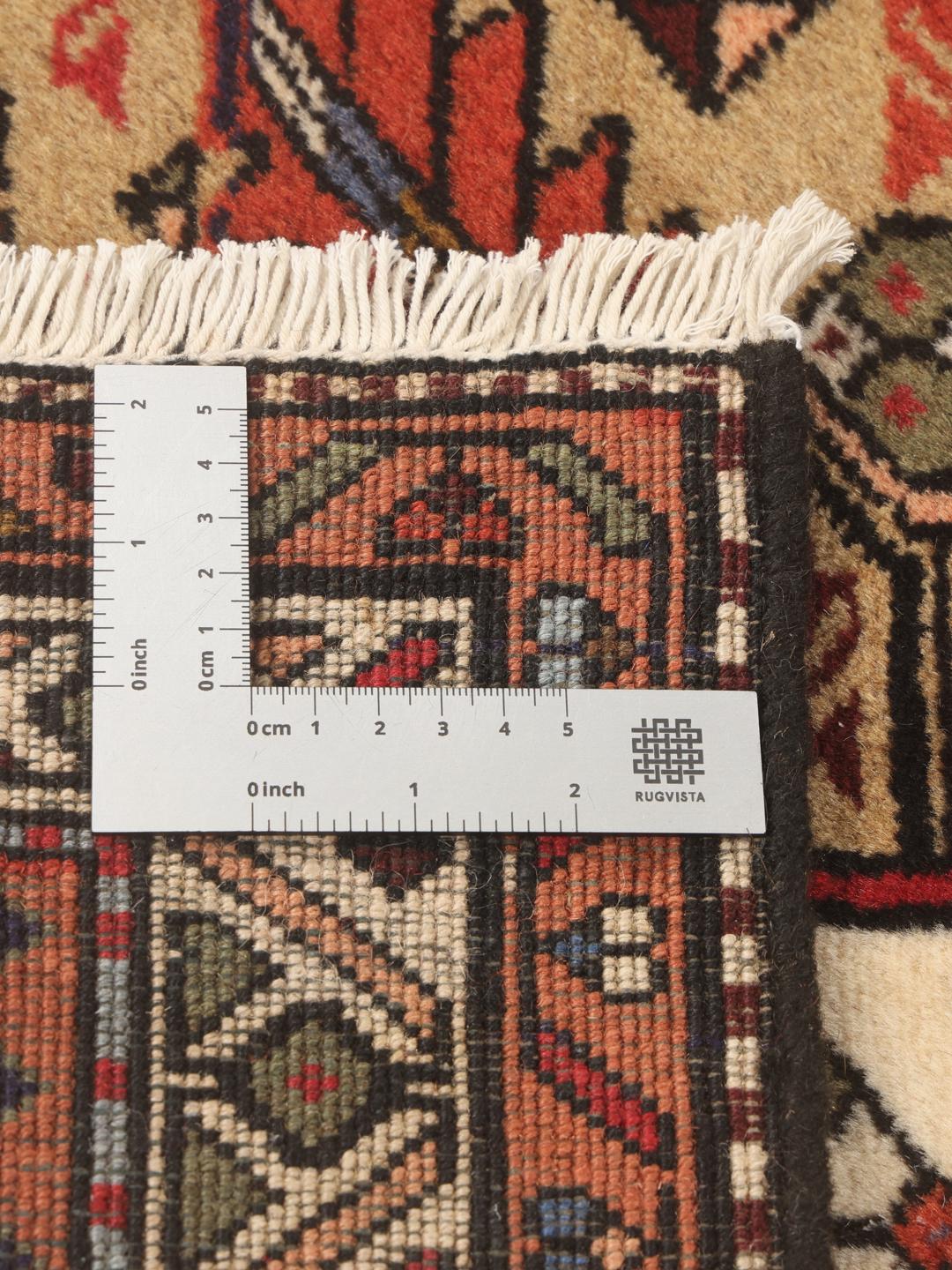 Een handgeknoopte Ardebil-loper uit het Midden-Oosten met een veelkleurig geometrisch ontwerp.