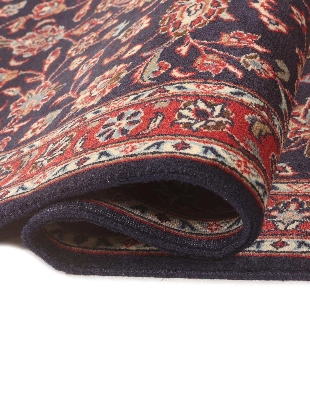 A hand-knotted Keshan runner with a dark blue field and intricate floral patterns.