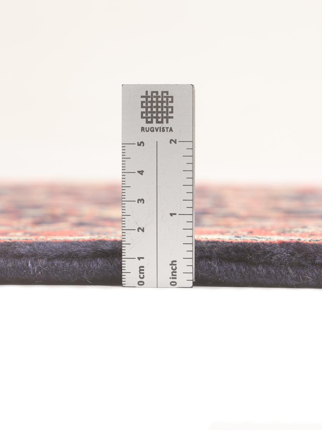 A hand-knotted Keshan runner with a dark blue field and intricate floral patterns.