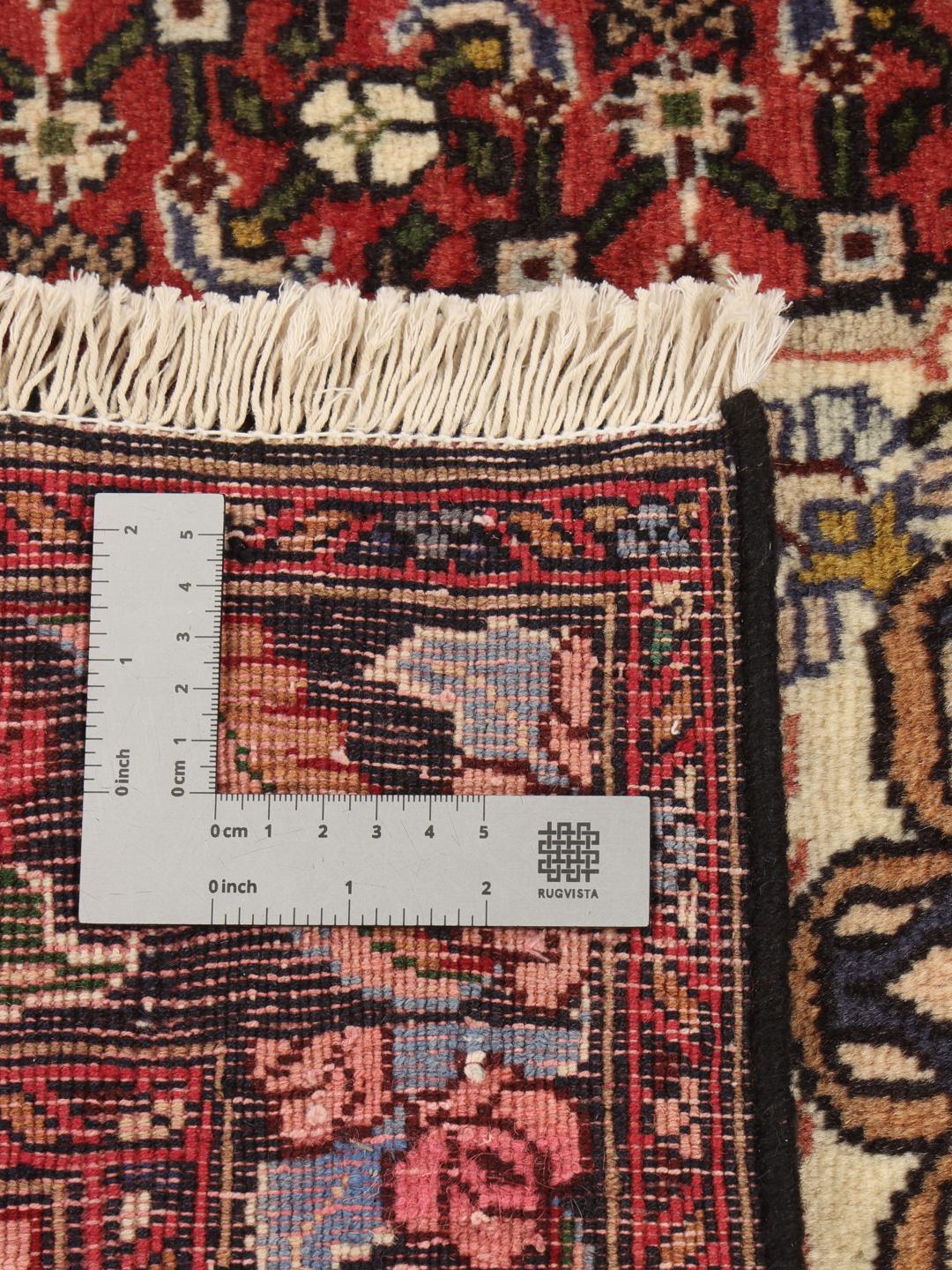 A hand-knotted Bidjar rug from the Middle East with a red field and intricate patterns.
