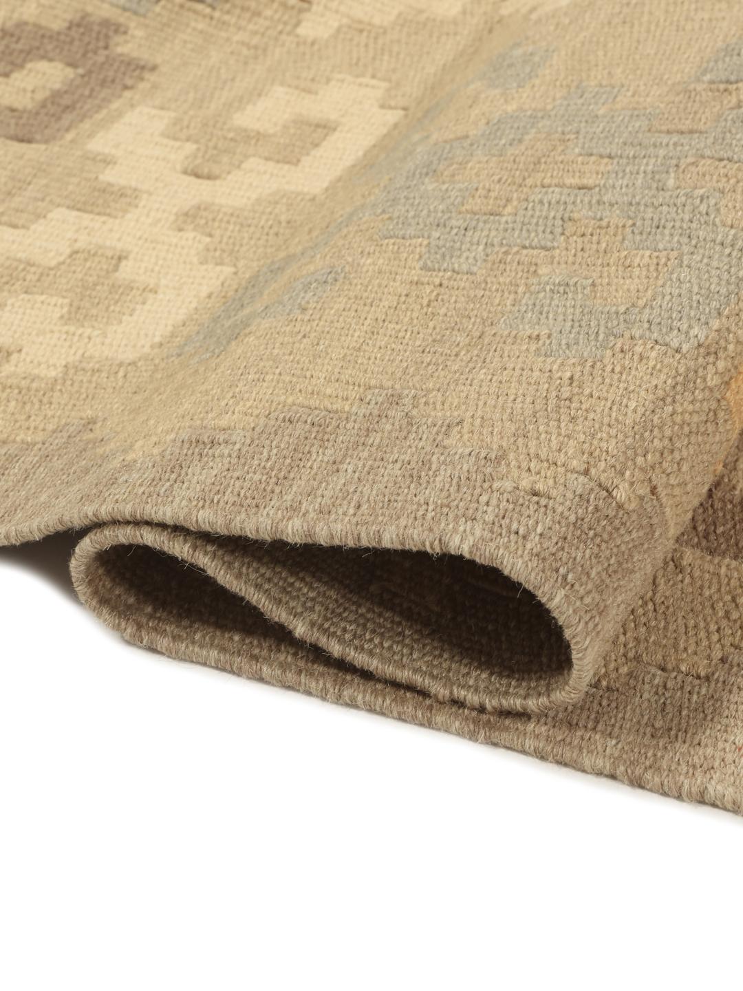 Et rektangulært håndvævet Kelim-tæppe fra Mellemøsten med et beige og flerfarvet geometrisk mønster.