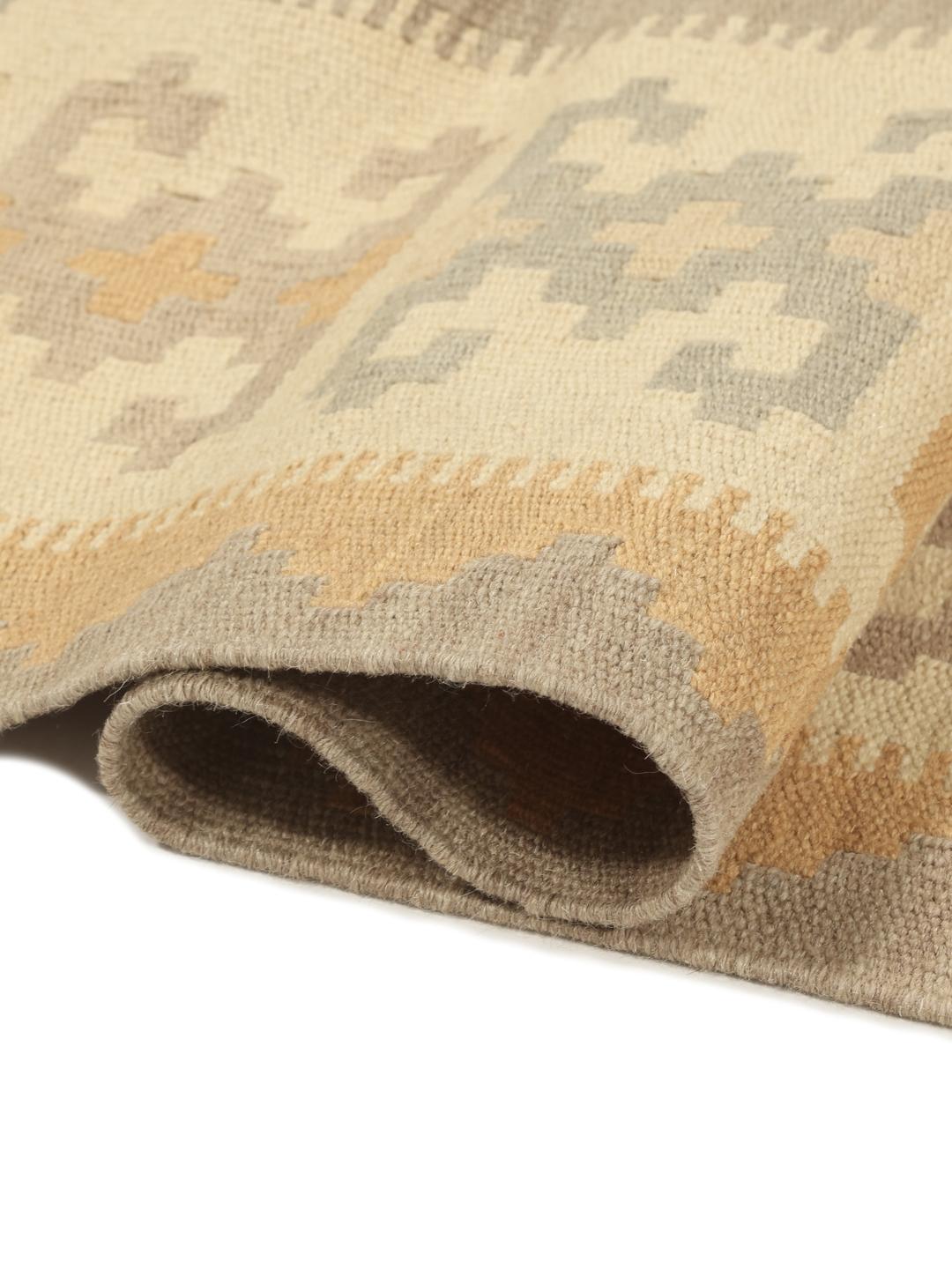 Un tappeto rettangolare Kilim Ghashghai tessuto a mano proveniente dal Medio Oriente con un motivo geometrico a rombi nei toni del beige e del grigio.