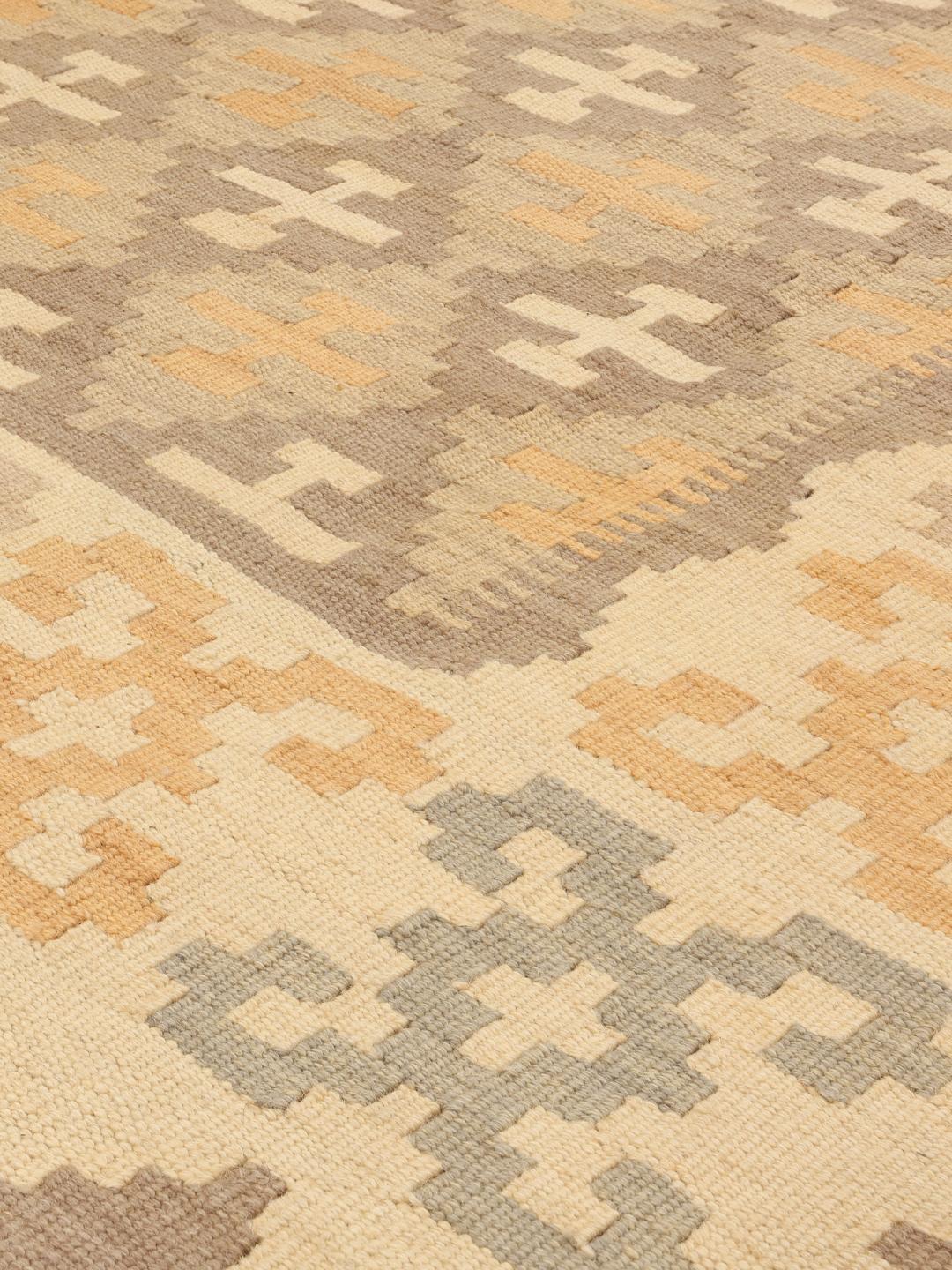 Un tapis kilim Ghashghai rectangulaire provenant du Moyen-Orient dans des tons beige et marron.
