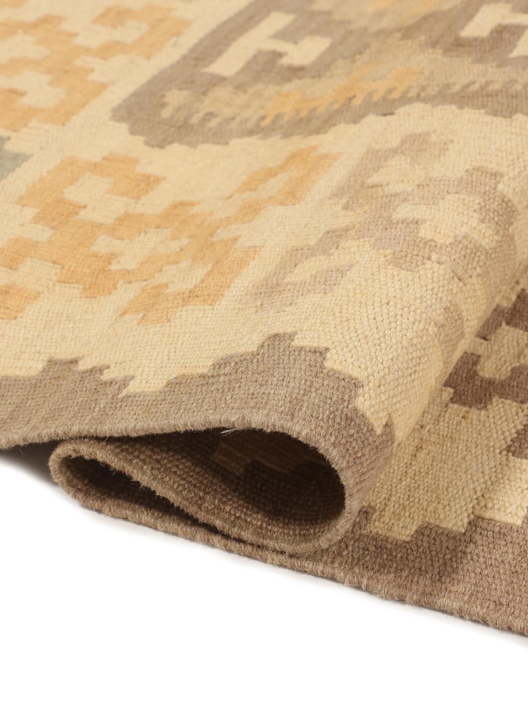 Un tapis kilim Ghashghai rectangulaire provenant du Moyen-Orient dans des tons beige et marron.