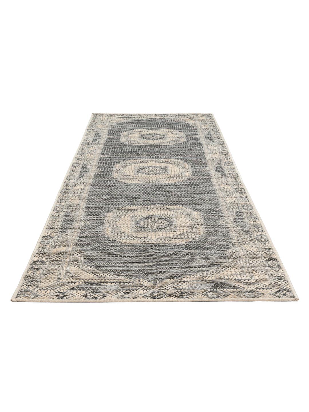 En mørkegrå og beige løber med et struktureret geometrisk design.
