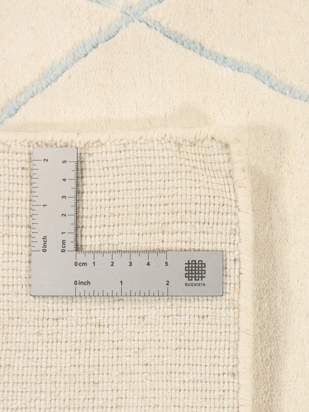 Ein beiger handgeknüpfter Teppich aus Indien mit einem feinen Rautenmuster.