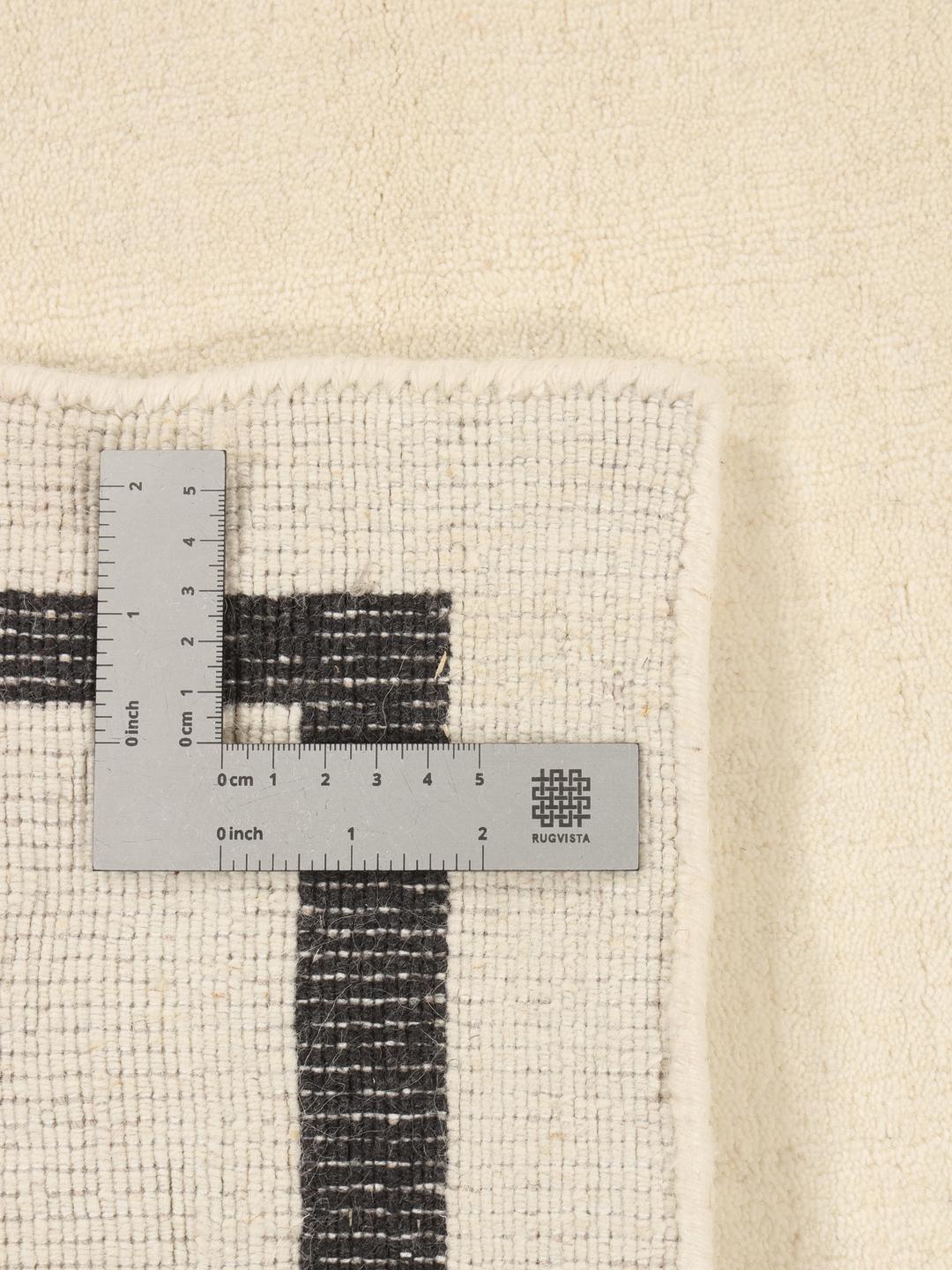 Hand-woven minimalist rug from India with a beige field and dark border