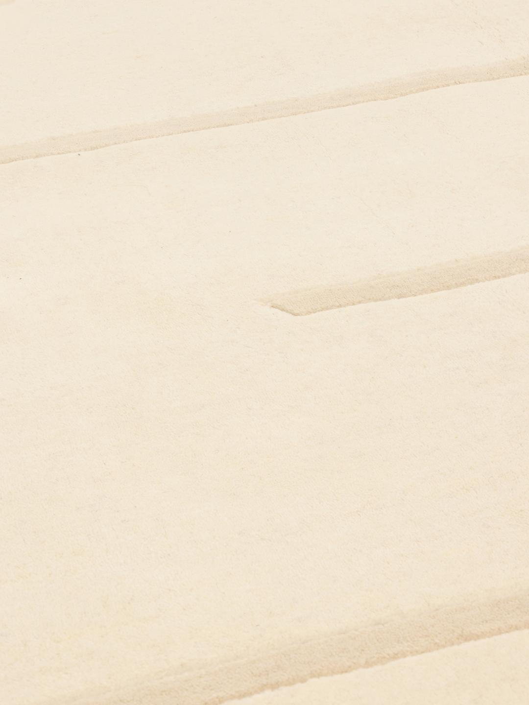 A minimalist beige hand-loomed rug from India featuring clean horizontal lines.