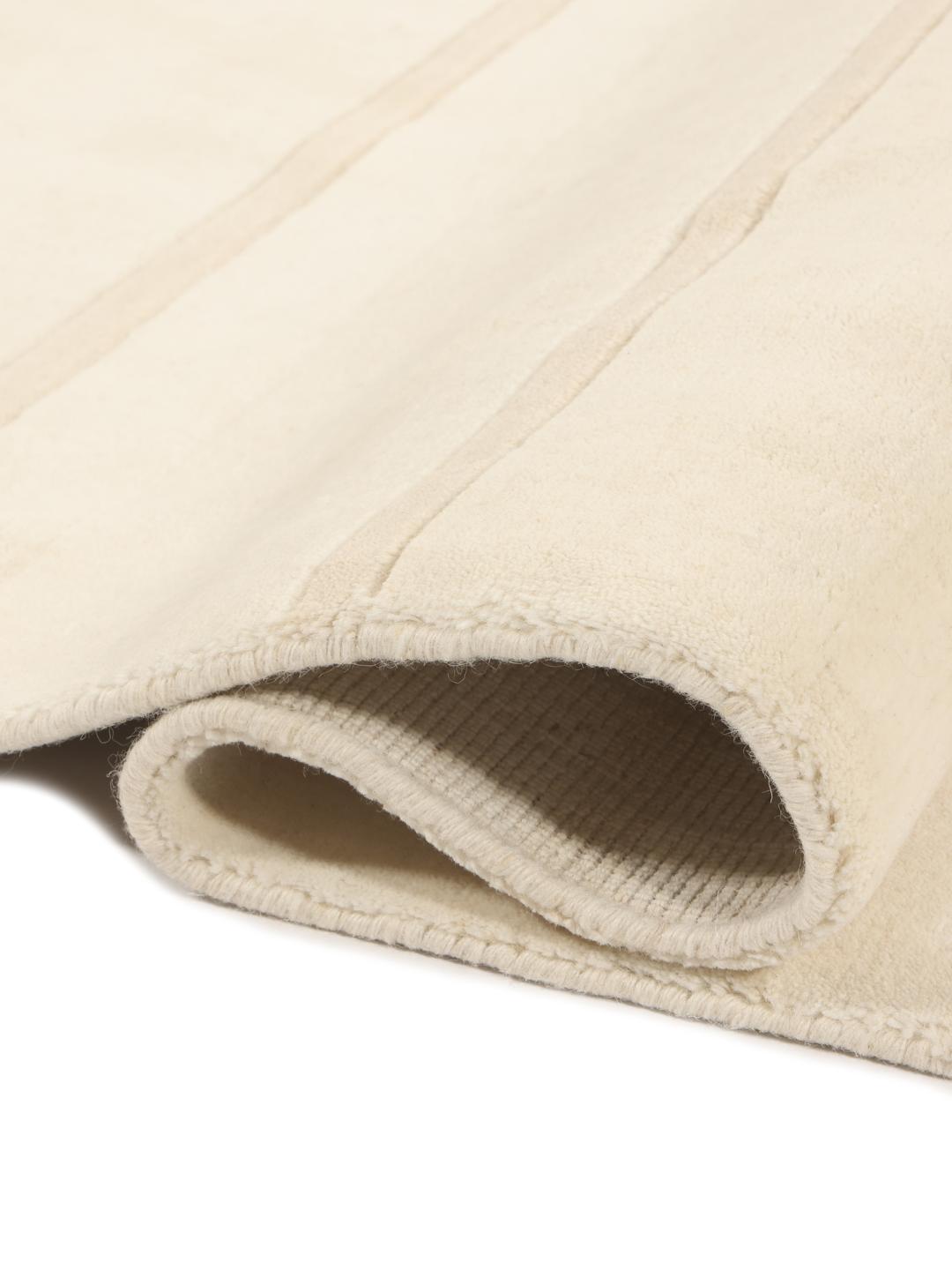 A minimalist beige hand-loomed rug from India featuring clean horizontal lines.