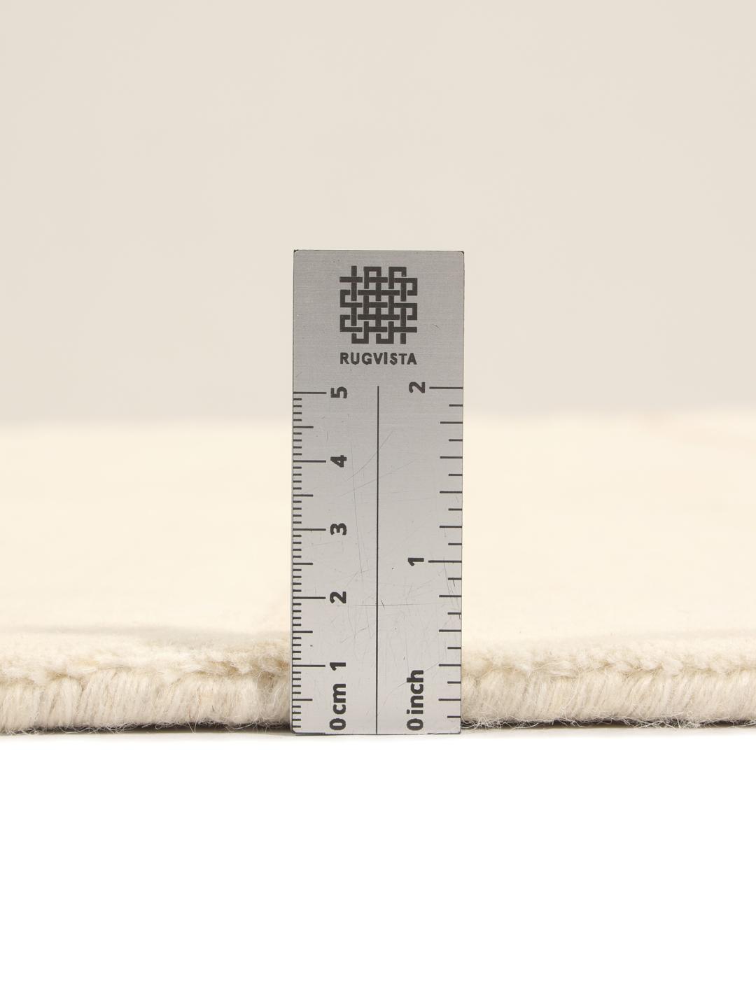 A minimalist beige hand-loomed rug from India featuring clean horizontal lines.