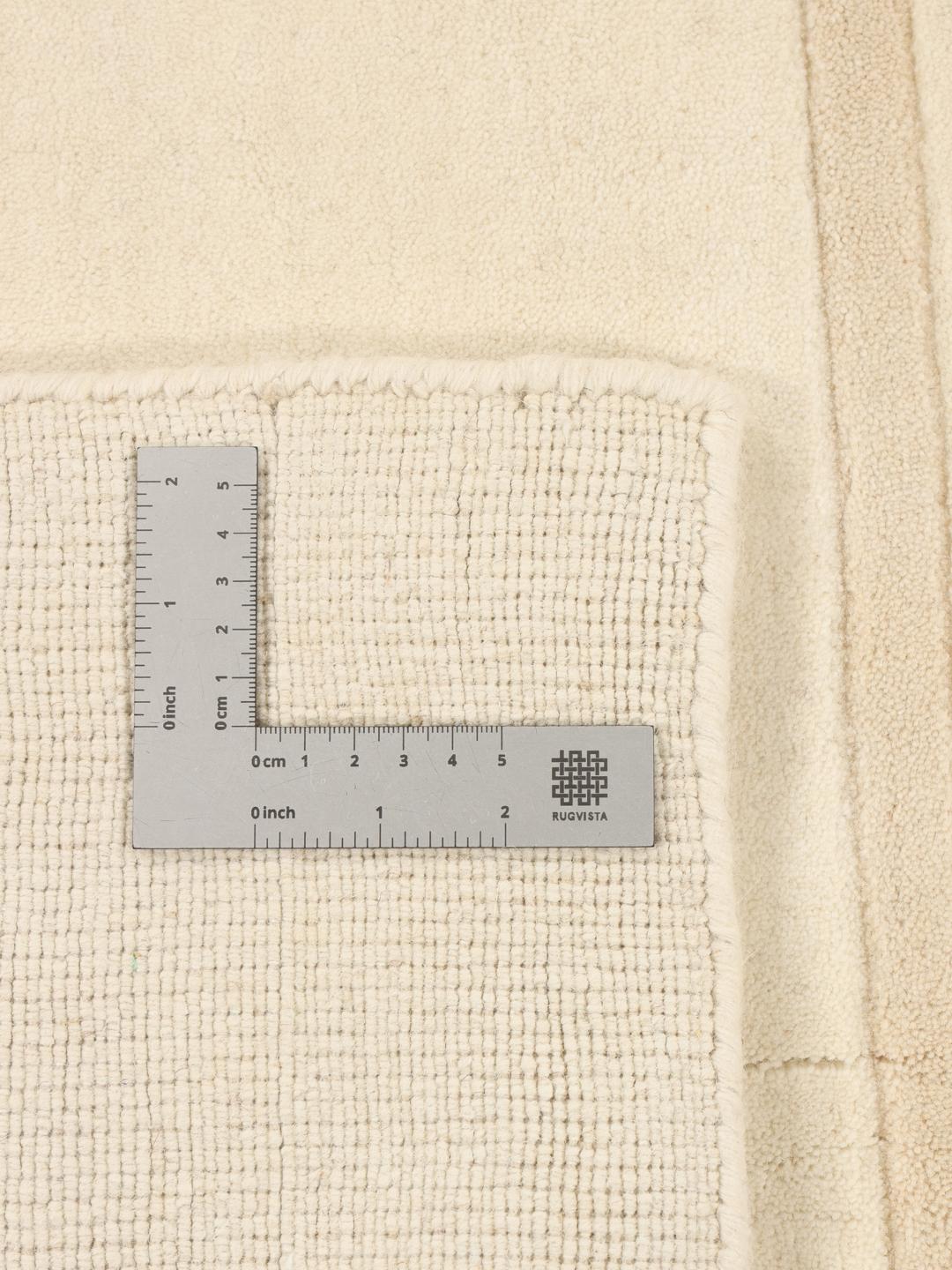 A minimalist beige hand-loomed rug from India featuring clean horizontal lines.