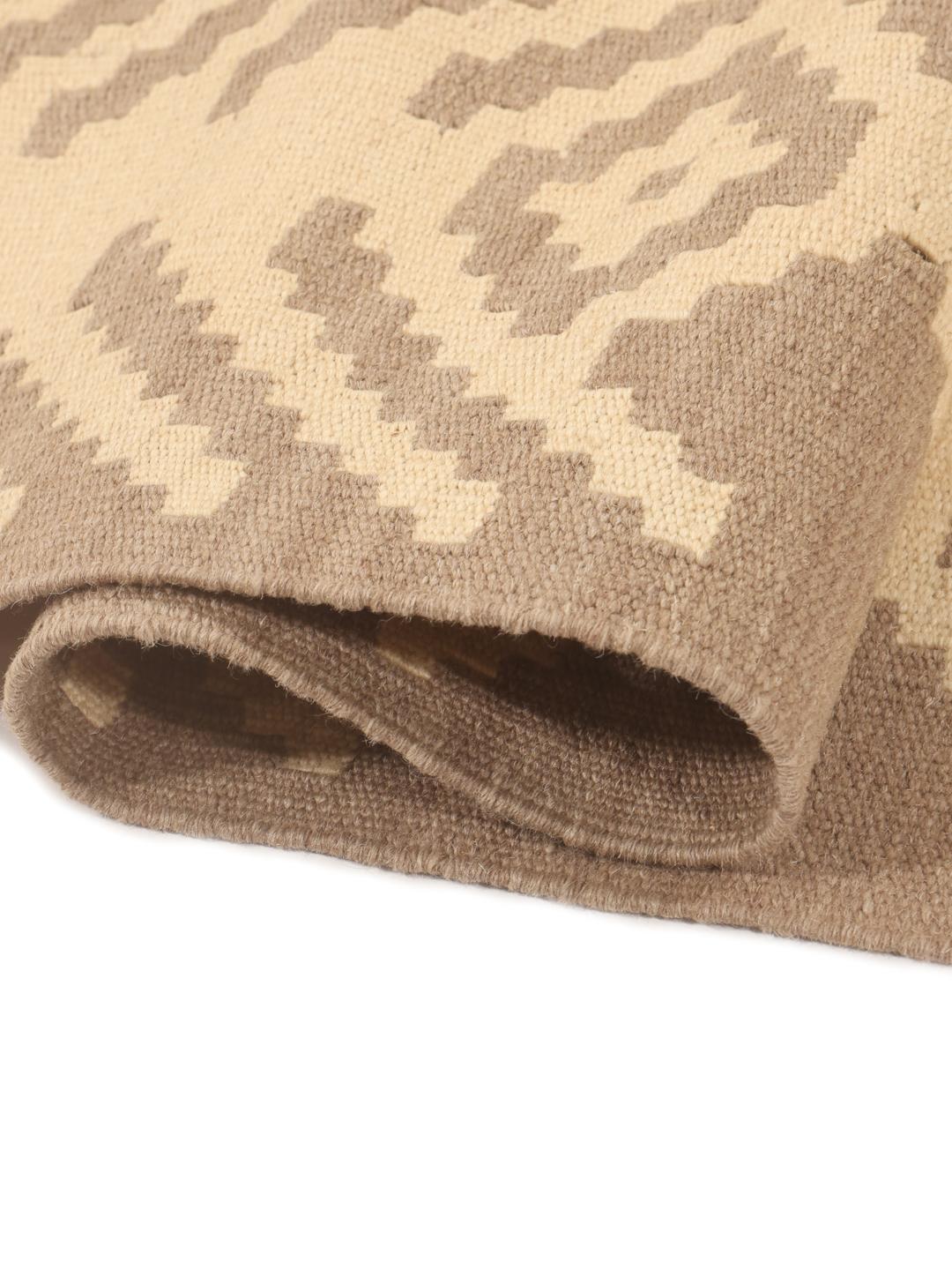 Un tapis kelim Ghashghai tissé à la main, dans des tons beige et brun, originaire du Moyen-Orient.