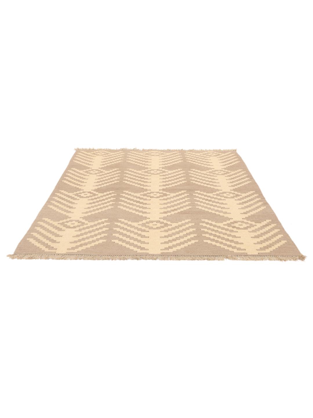 Un tapis kelim Ghashghai tissé à la main, dans des tons beige et brun, originaire du Moyen-Orient.