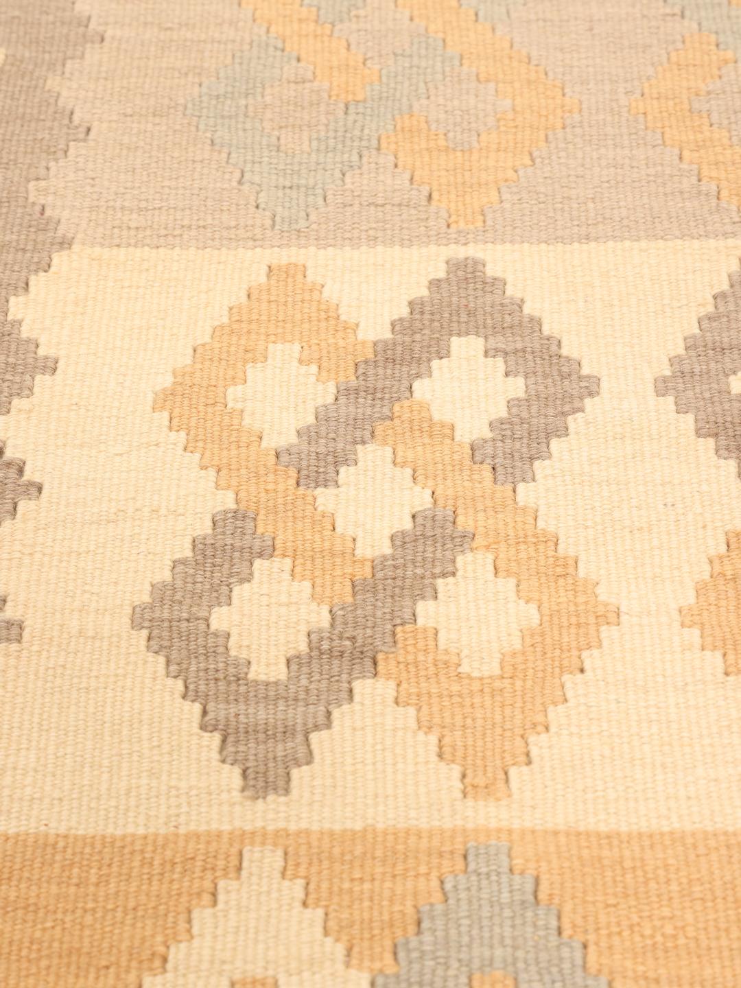 Runner Kilim tessuto a mano con motivi geometrici in tonalità marroni e terrose dal Medio Oriente