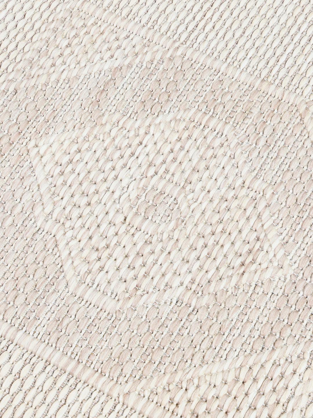 Tapis beige et blanc avec un motif de bordure géométrique
