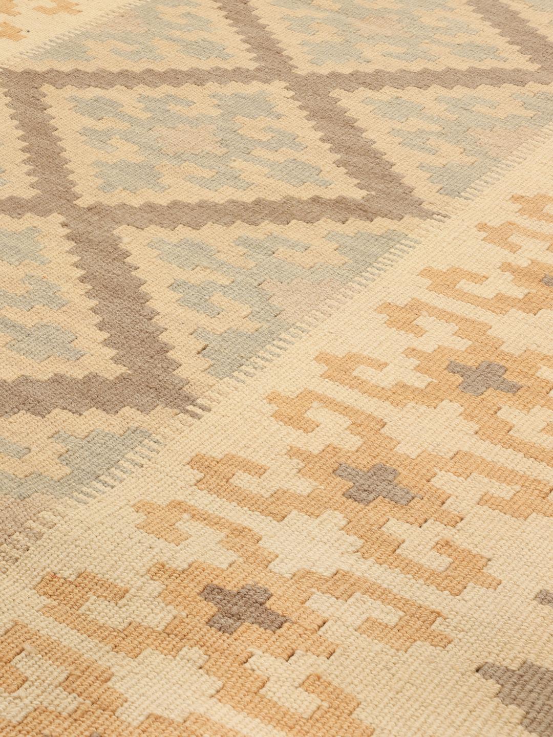 Tappeto kelim Ghashghai tessuto a mano con motivi geometrici a rombi in toni di beige, marrone e blu.