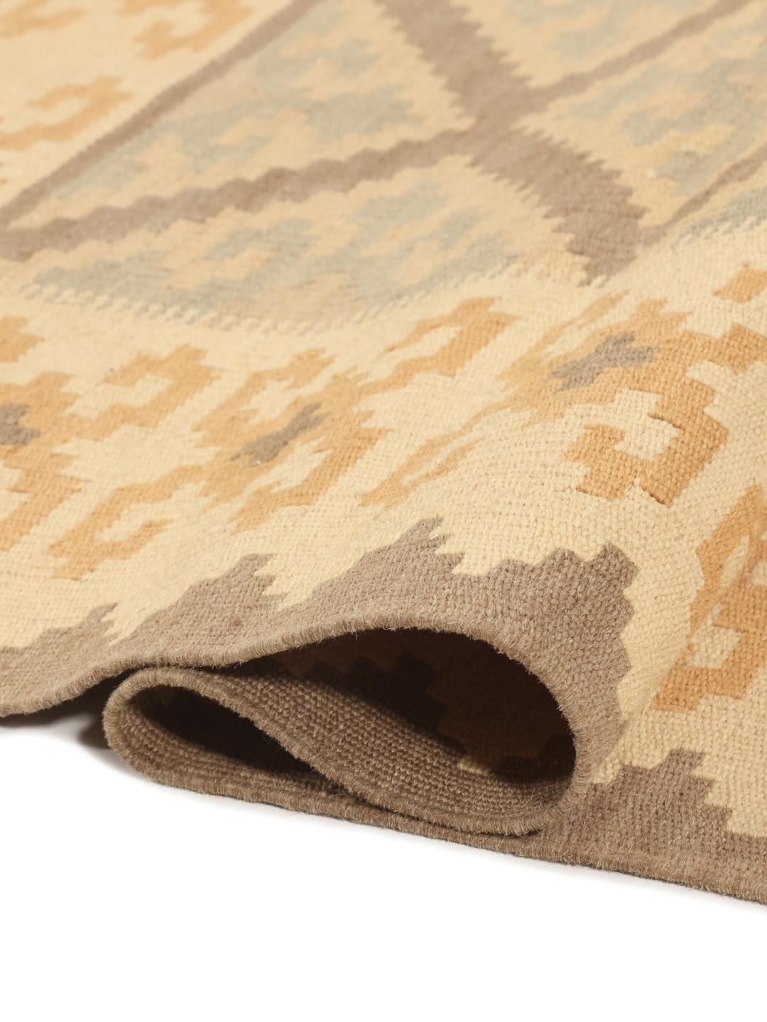 Tappeto kelim Ghashghai tessuto a mano con motivi geometrici a rombi in toni di beige, marrone e blu.