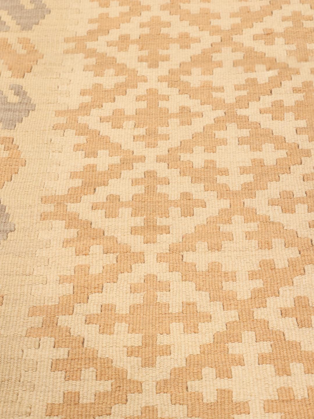 Passatoia Kilim tessuta a mano con motivi geometrici in toni beige e grigi proveniente dal Medio Oriente