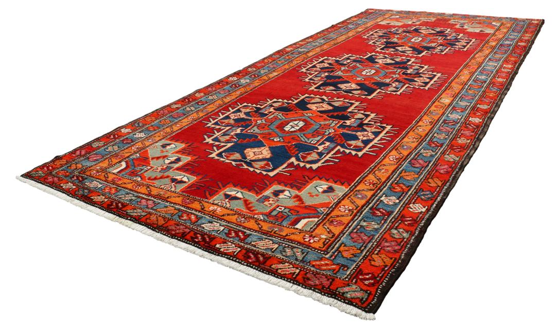 Met de hand geknoopte loper uit het Midden-Oosten in rood met geometrische medaillons