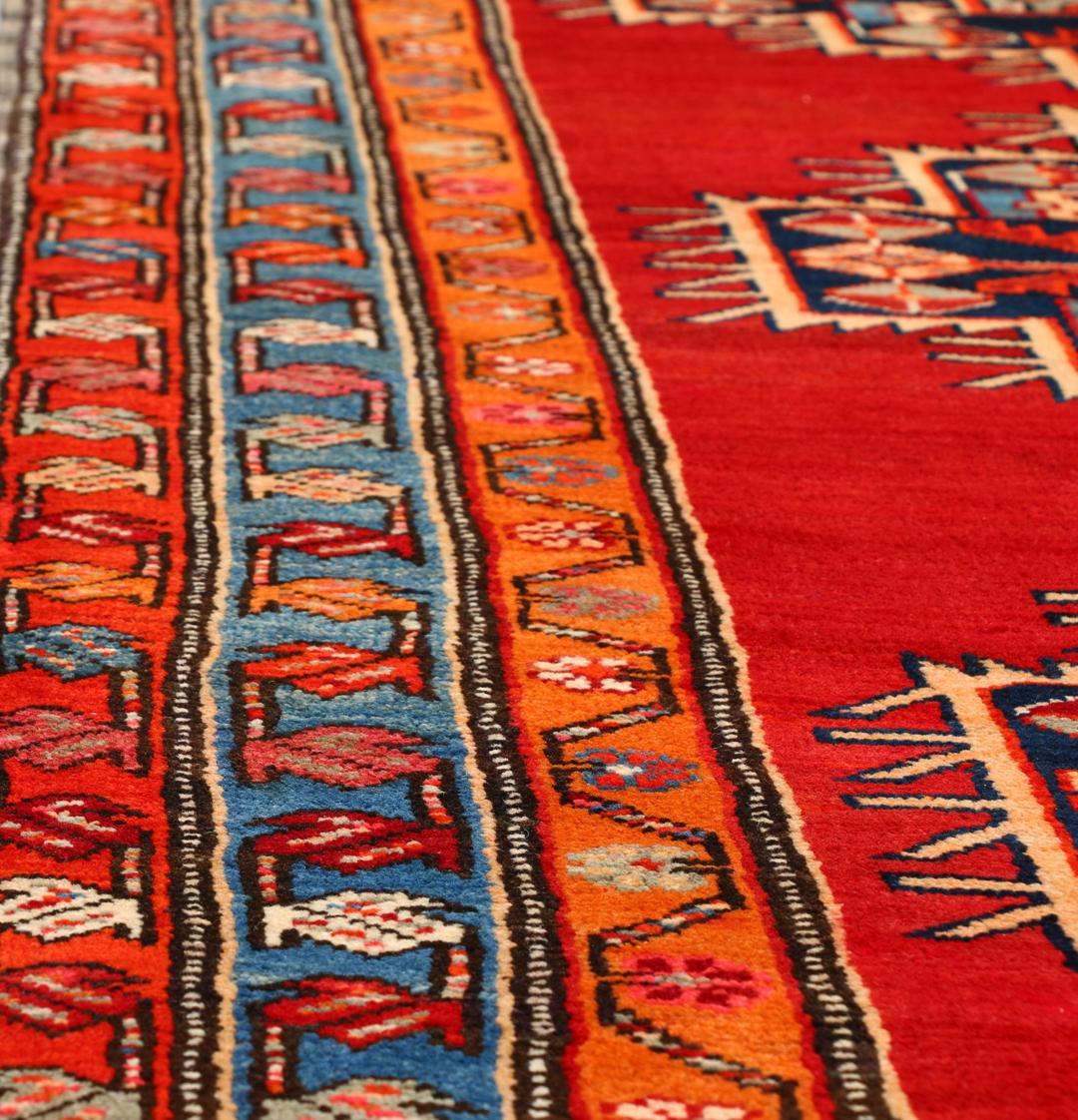 Met de hand geknoopte loper uit het Midden-Oosten in rood met geometrische medaillons