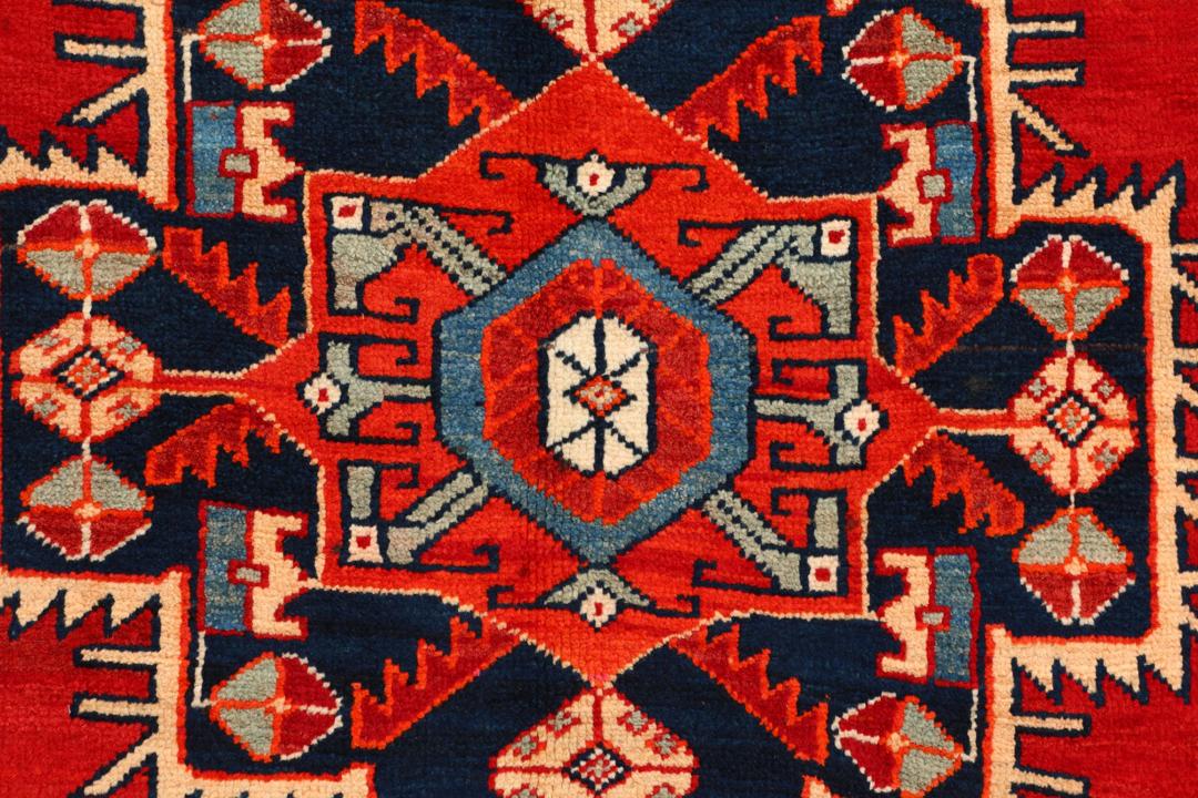 Met de hand geknoopte loper uit het Midden-Oosten in rood met geometrische medaillons