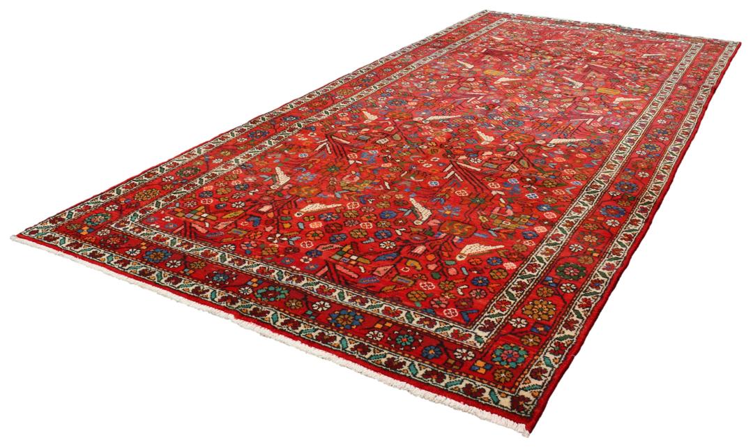 A hand-knotted Hamadan rug from the Middle East with a vibrant red field and bird motifs.