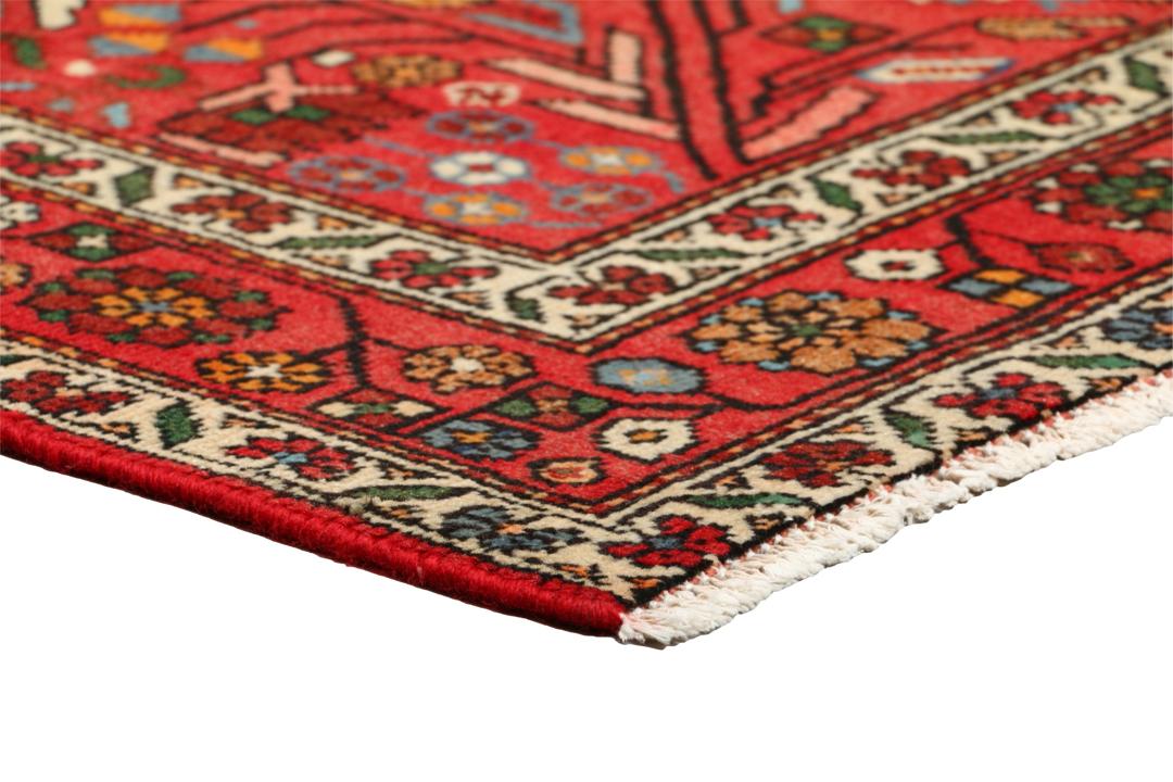 A hand-knotted Hamadan rug from the Middle East with a vibrant red field and bird motifs.