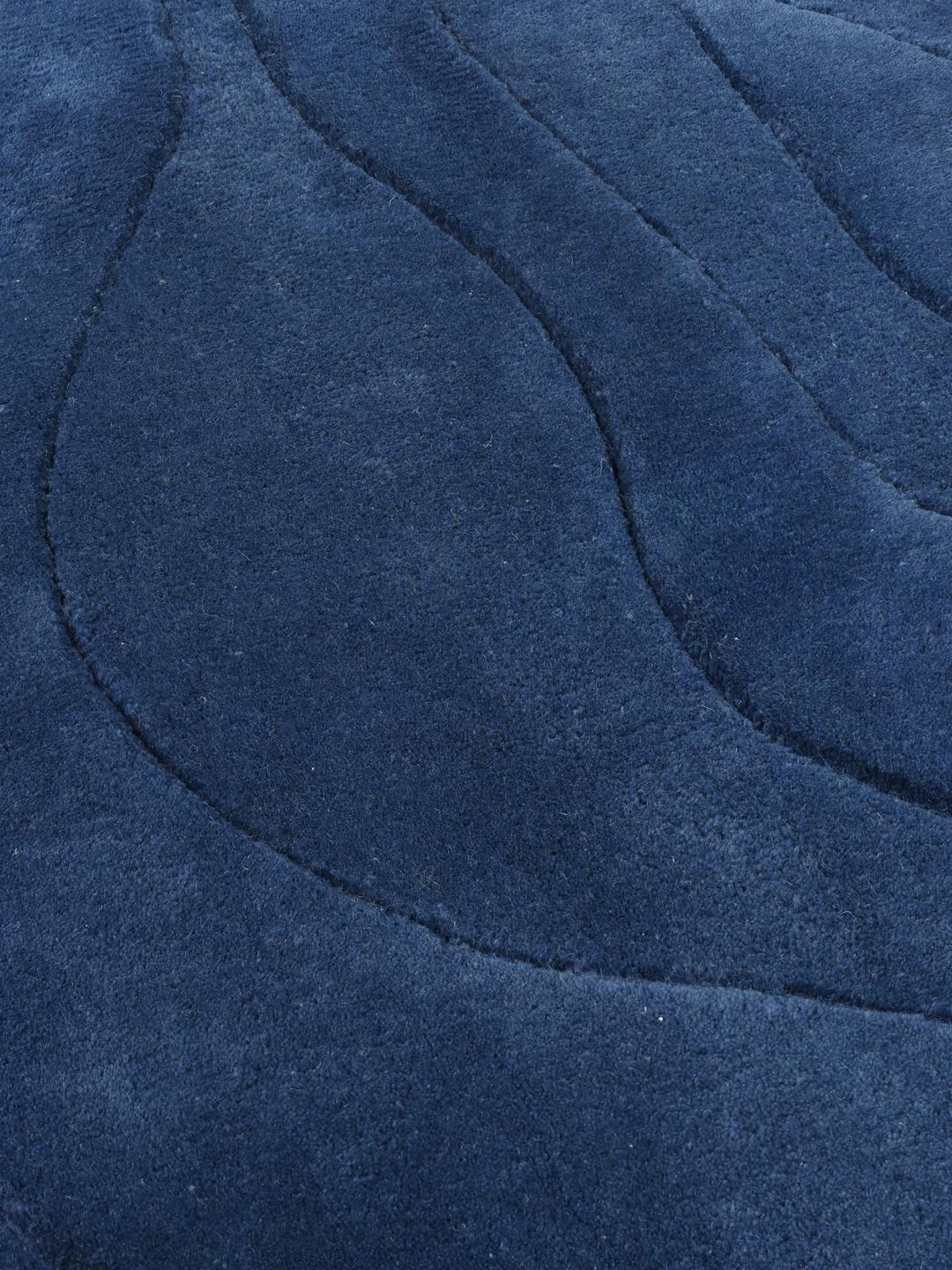 Tapis bleu de forme irrégulière avec un motif ondulé