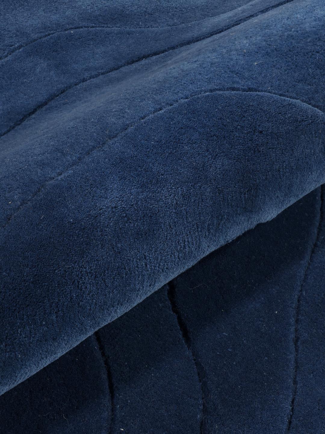 Tapis bleu de forme irrégulière avec un motif ondulé