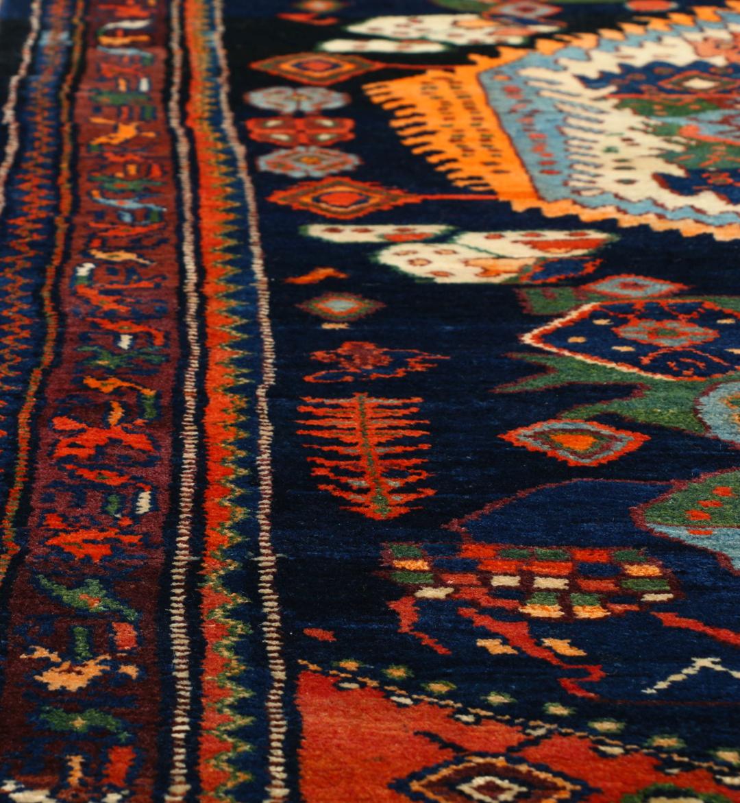 Een met de hand geknoopt Lillian-tapijt uit het Midden-Oosten met een donkerblauw en oranje kleurenpalet.