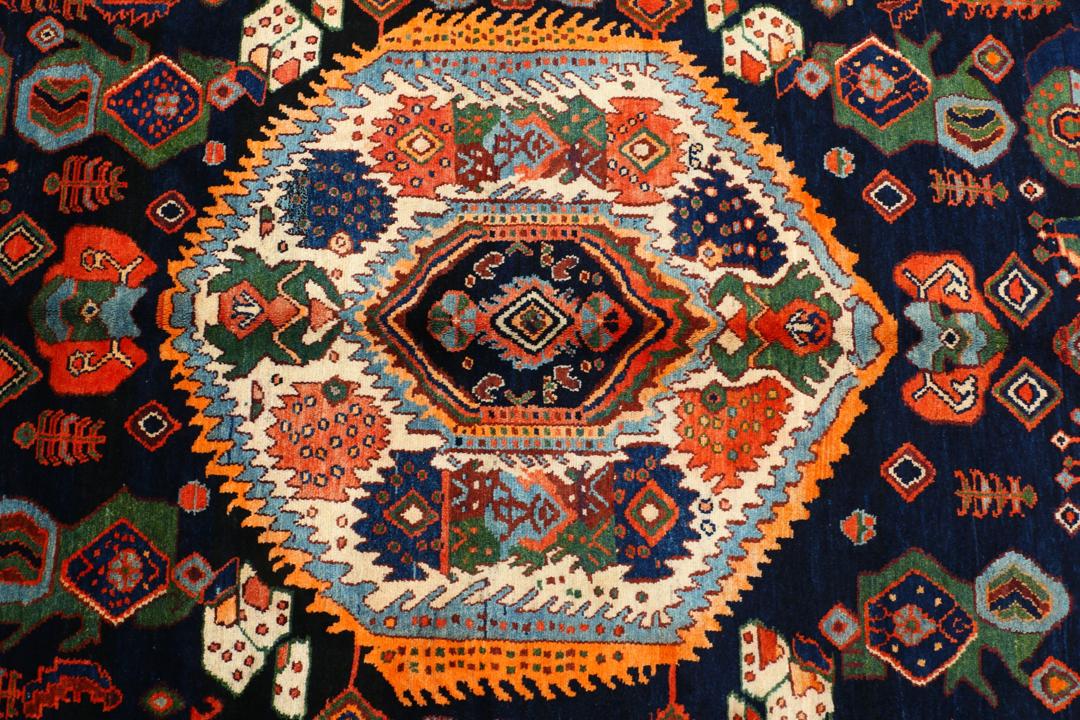 Een met de hand geknoopt Lillian-tapijt uit het Midden-Oosten met een donkerblauw en oranje kleurenpalet.