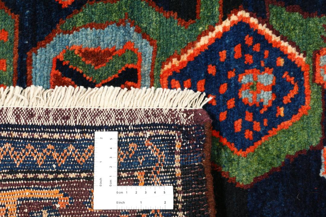 Een met de hand geknoopt Lillian-tapijt uit het Midden-Oosten met een donkerblauw en oranje kleurenpalet.