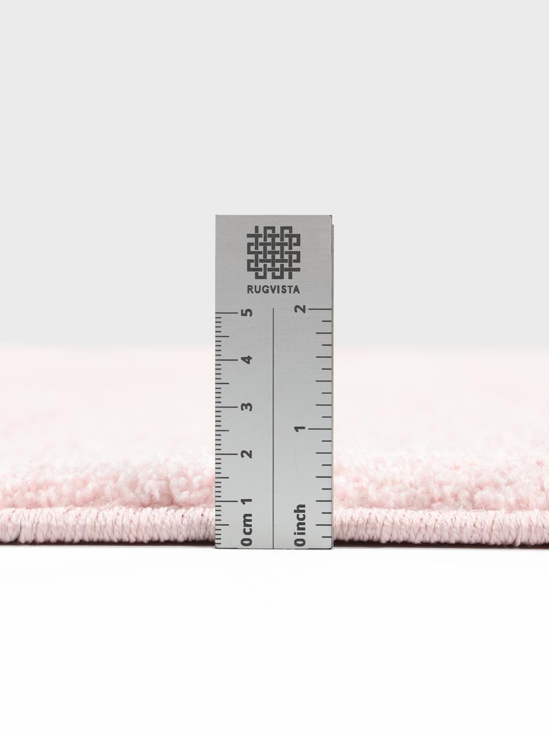 Tapis rose à la texture douce et à la silhouette arrondie.