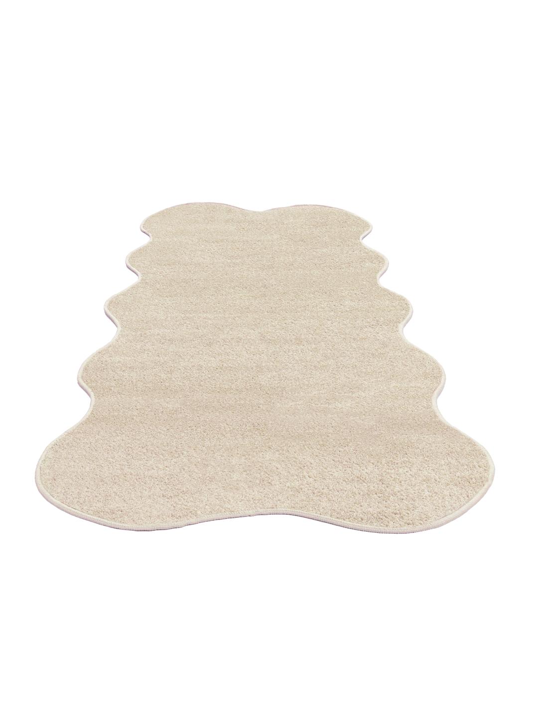Beige tæppe med en uregelmæssig form og blød luv.